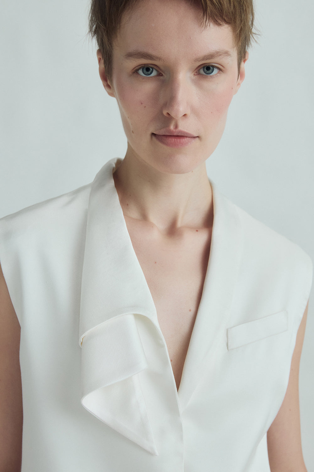 VICKTEERUT Sleeveless Blouse with Sculptural Rolled Neckline เสื้อแขนกุด ปกม้วน